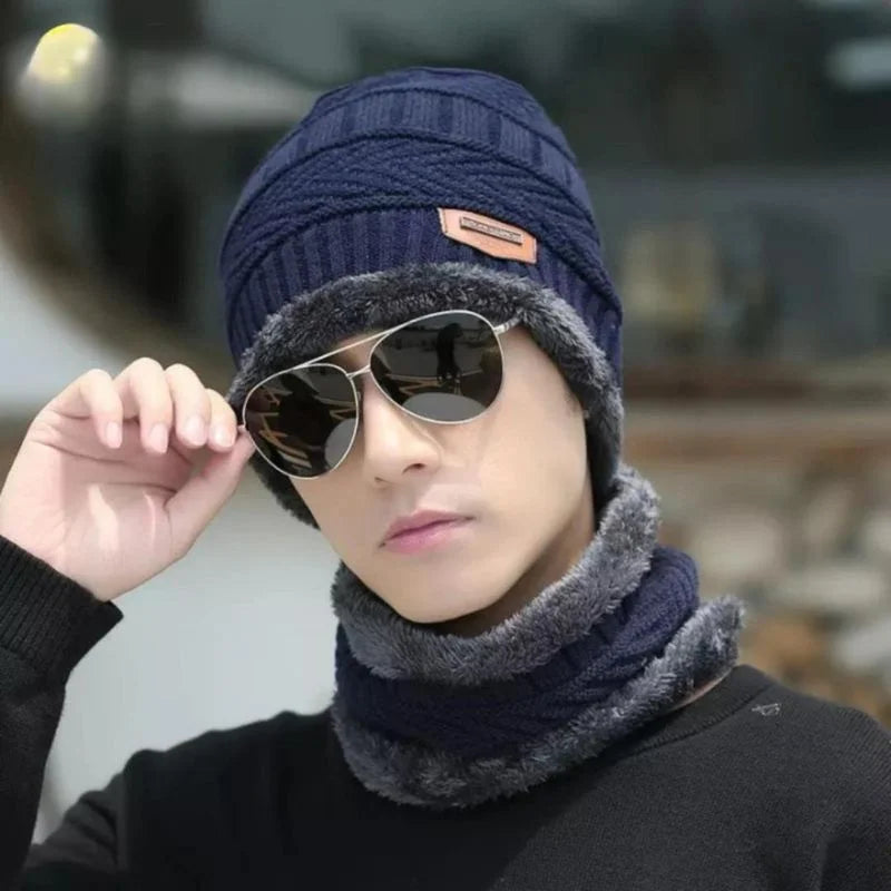 Hunt PK Person wearing a navy blue knit hat and gray scarf with sunglasses, blurred background