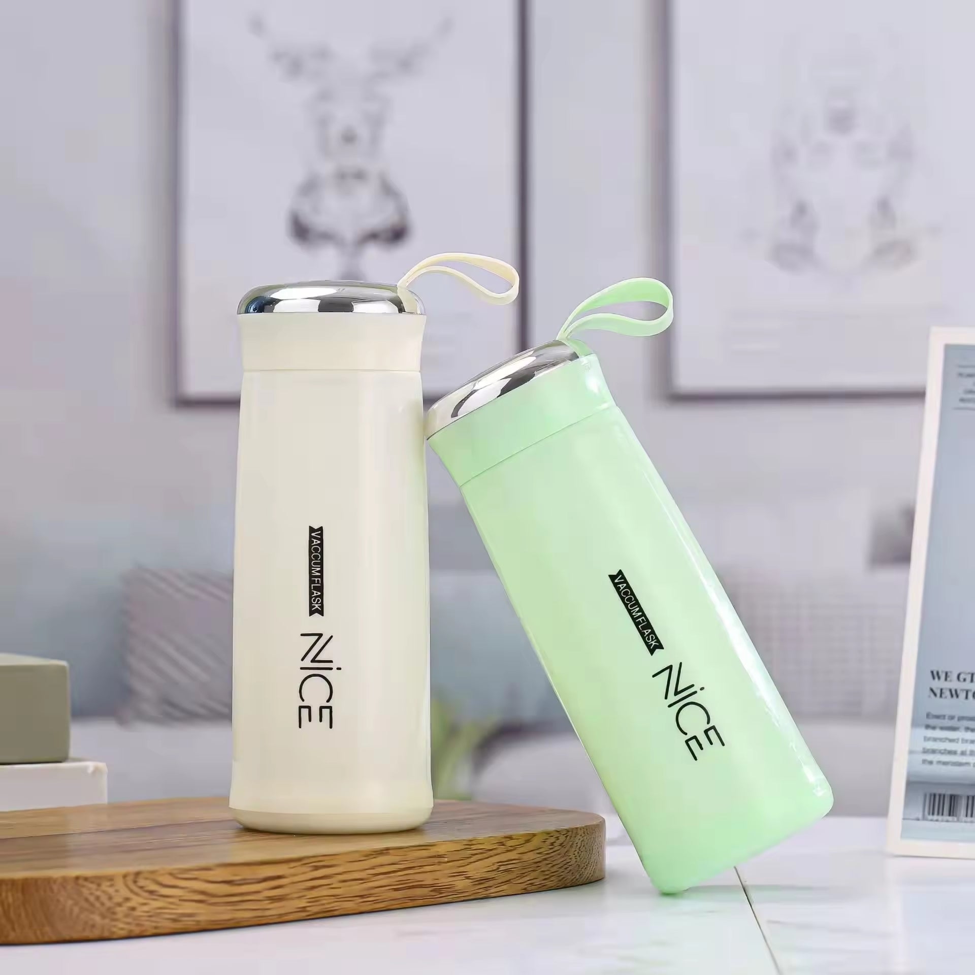 Hunt PK Two insulated bottles, one white and one light green, on a wooden surface with a blurred background.